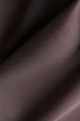 Pollera midi color marrón con leve brillo y caída suave. Modelo de tiro alto con elástico oculto en la cintura y leve vuelo en el bajo.