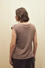 Top negro sin mangas con textura metalizada y leve acabado glitter, de silueta recta y cuello a la base.