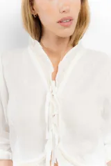 Blusa color blanco de lino, con mangas 3/4 y volados en el frente. Se ata con lazos en el centro.