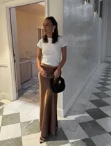 Pollera larga de seda color caramelo con elástico en la cintura.
