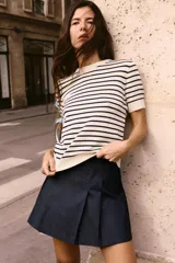 Top de punto color crema con rayas horizontales azul marino, cuello redondo y mangas cortas.
