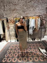 Pollera midi color verde oliva de satén, con frunces en el frente y abertura lateral.