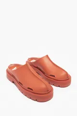 Zueco negro engomado con suela gruesa y diseño minimalista.
