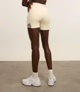 Bermuda deportiva color crema, confeccionada en microfibra pesada, con cintura elástica con lettering GYM texturizado y bolsillos laterales.