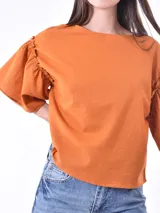 Blusa de corte amplio color verde, con mangas de volantes y diseño holgado.