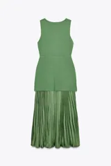 Vestido largo verde con escote redondo y sisas amplias. La parte superior es de punto liso y la falda es plisada de tejido satinado.