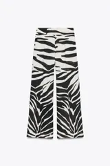Pantalón de tiro medio con estampado animal cebra, corte palazzo y cierre lateral con cremallera oculta.