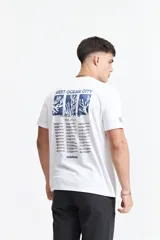 Remera blanca de algodón con cuello redondo y manga corta. Presenta un estampado rectangular en el frente con un diseño abstracto en tonos celeste y azul, y el logo de la marca Mistral.