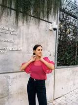 Blusa fucsia transparente de plumetí con mangas abullonadas y cuello redondo. Incluye musculosa al tono.