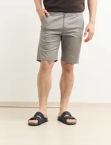 Bermuda de gabardina color verde con bolsillos laterales y traseros.