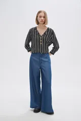 Pantalón de lyocell azul con bolsillos, corte holgado y de calce alto.