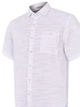 Camisa de manga corta blanca con textura multicolor, confeccionada en lino orgánico y tencel. Tiene bolsillo en el pecho con botón.