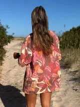 Camisa oversize de manga corta con estampado floral en tonos rosados, naranjas y crema. Confeccionada en una mezcla de lino y viscosa, presenta cuello camisero y cierre frontal con botones.