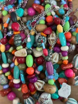 Collar corto con cuentas de cerámica, acrílico y piedras de diferentes colores y formas. Cierre con cadena de acero quirúrgico y gancho regulable.