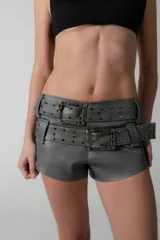 Short gris de eco cuero con doble cinturón desmontable con hebillas metálicas y tachas.
