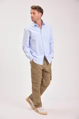 Camisa celeste de manga larga con cuello clásico y cierre abotonado.