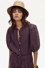 Camisa de lino a cuadros color morado y naranja, con cuello mao, cierre frontal con botones de nácar y mangas abullonadas hasta el codo.