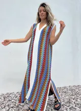 Vestido largo de tejido con diseño geométrico en tonos celeste, marrón, rojo y blanco. Tiene escote en V y aberturas laterales.