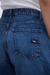 Jean azul de tiro alto, corte holgado tipo globo desde la cadera hasta la rodilla, estrechándose hacia el bajo.