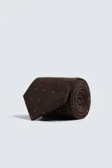 Corbata ancha para hombre confeccionada en tejido de seda color marrón con lunares blancos.