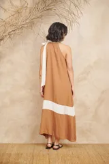Vestido largo color marrón con corte debajo del busto y falda acampanada. Presenta cuello halter con lazo blanco.