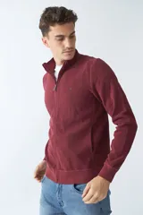 Campera marrón de algodón con cierre frontal, cuello alto, bolsillos laterales, puños y logo bordado en el pecho.