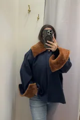 Sobre camisa azul marino con cuello y puños de cuero de cordero color óxido.