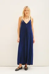 Vestido largo plisado color azul eléctrico, con breteles regulables, escote redondo en el frente y espalda baja. Confeccionado en viscosa con hilos de lurex a tono y moldería amplia.