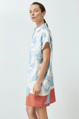 Túnica corta color blanco con estampado floral celeste y base color salmón.