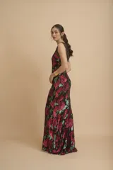 Vestido largo de fiesta color negro, con escote redondo y bordado de lentejuelas formando flores rojas y verdes.