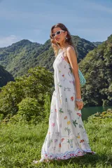 Vestido largo blanco con estampado de corales en tonos naranja, rosa, verde y lila. Diseño evasé con breteles finos regulables y escote recto.