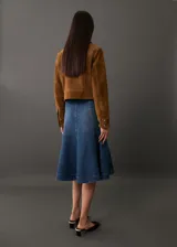 Falda midi de denim azul con corte evasé, cintura alta y bolsillos laterales.