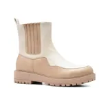 Bota Chelsea de cuero sintético charolado color negro, con elásticos laterales y tirador trasero. Tiene suela track y plataforma.