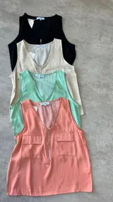 Musculosa color beige con cuello en V y cierre frontal con cremallera. Presenta dos bolsillos con solapa en el pecho y corte holgado.