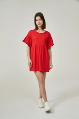 Vestido corto rojo coral, de corte holgado, con mangas cortas con volados y cuello redondo.