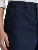 Short de vestir azul marino, de corte recto, con bolsillos laterales y traseros. Se ajusta a la cintura con cinturón de cuero marrón.