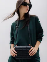 Sudadera verde oscuro de manga larga con corte regular y bolsillo en la manga.