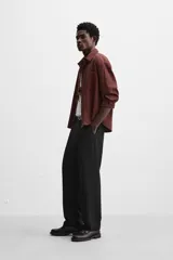 Pantalón negro de corte recto confeccionado en tejido fluido con mezcla de viscosa, con bolsillos frontales y traseros de vivo.