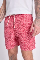 Short de baño rojo con estampado de arabescos blancos, cintura elástica y cordón ajustable.