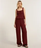 Blusa texturizada color borgoña, con breteles anchos, escote cuadrado, lazo en el busto y volado en el ruedo.