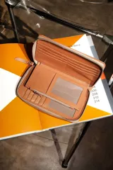 Billetera negra de cuero con cierre de cremallera, múltiples ranuras para tarjetas, compartimento para billetes y monedero con cremallera.