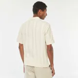Camisa de manga corta color crema con textura de punto y botones de madera.