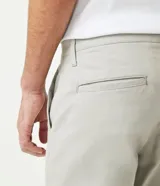 Pantalón de vestir color marrón, de corte slim y largo cropped. Confeccionado en tejido de algodón liso, con bolsillos laterales y traseros. Cierre frontal con botón y cremallera.