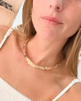 Choker rígido de metal dorado con acabado martillado irregular, de estilo ancho y plano.