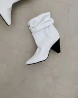 Botines dorados de cuero vacuno con punta fina y tacón aguja.