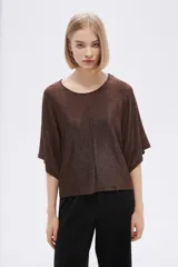 Remera manga corta gris con lurex, de corte holgado y cuello redondo.