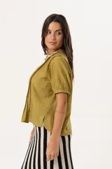 Blusa color verde oliva con cuello mao, mangas cortas abullonadas y cierre frontal con botones.