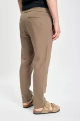 Pantalón casual color marrón claro, confeccionado en lino con suave elasticidad, corte recto y cintura con cordón ajustable.