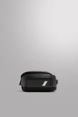 Neceser deportivo negro con compartimento principal con cierre mediante hebilla de liberación rápida, bolsillo lateral con cierre mediante cremallera y asa de mano. Marca Zara Athleticz.