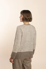 Cardigan tejido con efecto fantasia color crema. Una prenda de silueta amplia y cómoda. Tejido en 100% lana fina sin teñir.